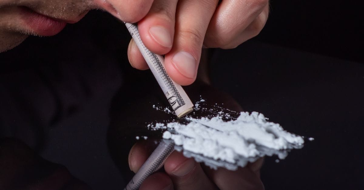man snorting lines of cocaine powder