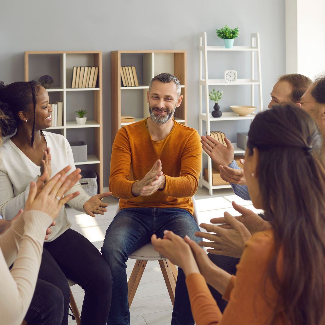Happy Patients Applauding Mature Psychologist or Therapist after Group Therapy Session